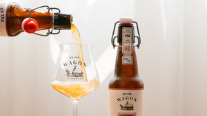 On The Wagon Assam & Darjeeling Kombucha being poured next to a full bottle