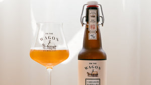 A bottle of On The Wagon Cardamom & White Tea kombucha with a glass filled with kombucha