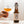 A hand holding a glass filled with kombucha, alongside a bottle of On The Wagon Cardamom & White Tea kombucha