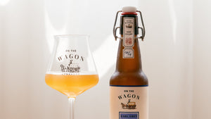 A bottle of Earl Grey On The Wagon kombucha with a glass filled with kombucha