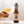 A bottle of Earl Grey On The Wagon kombucha with a hand holding a glass filled with kombucha