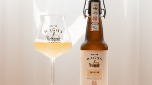 On The Wagon Jasmine Green Tea kombucha with a glass filled with kombucha