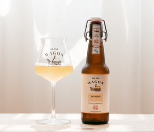 On The Wagon Jasmine Green Tea kombucha with a glass filled with kombucha