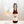 Bottle and glass of 'On the Wagon' Lemongrass & Lime kombucha on a wooden surface with a white background
