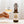 Bottle of On The Wagon Kombucha Malt & Hops flavor with hand holding a glass