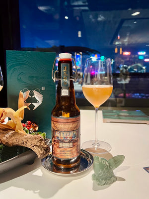 On The Wagon Kombucha x Lai Ching Heen Regent Hotel custom Earl Grey label bottle and a glass of kombucha