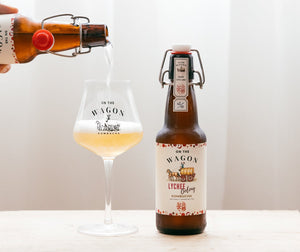 On The Wagon Lychee Oolong kombucha bottle being poured beside a glass in Hong Kong